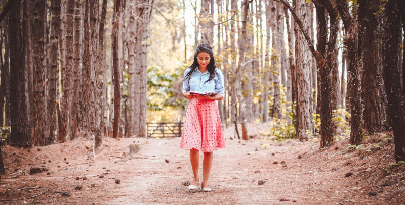 mulher lendo livro na floresta